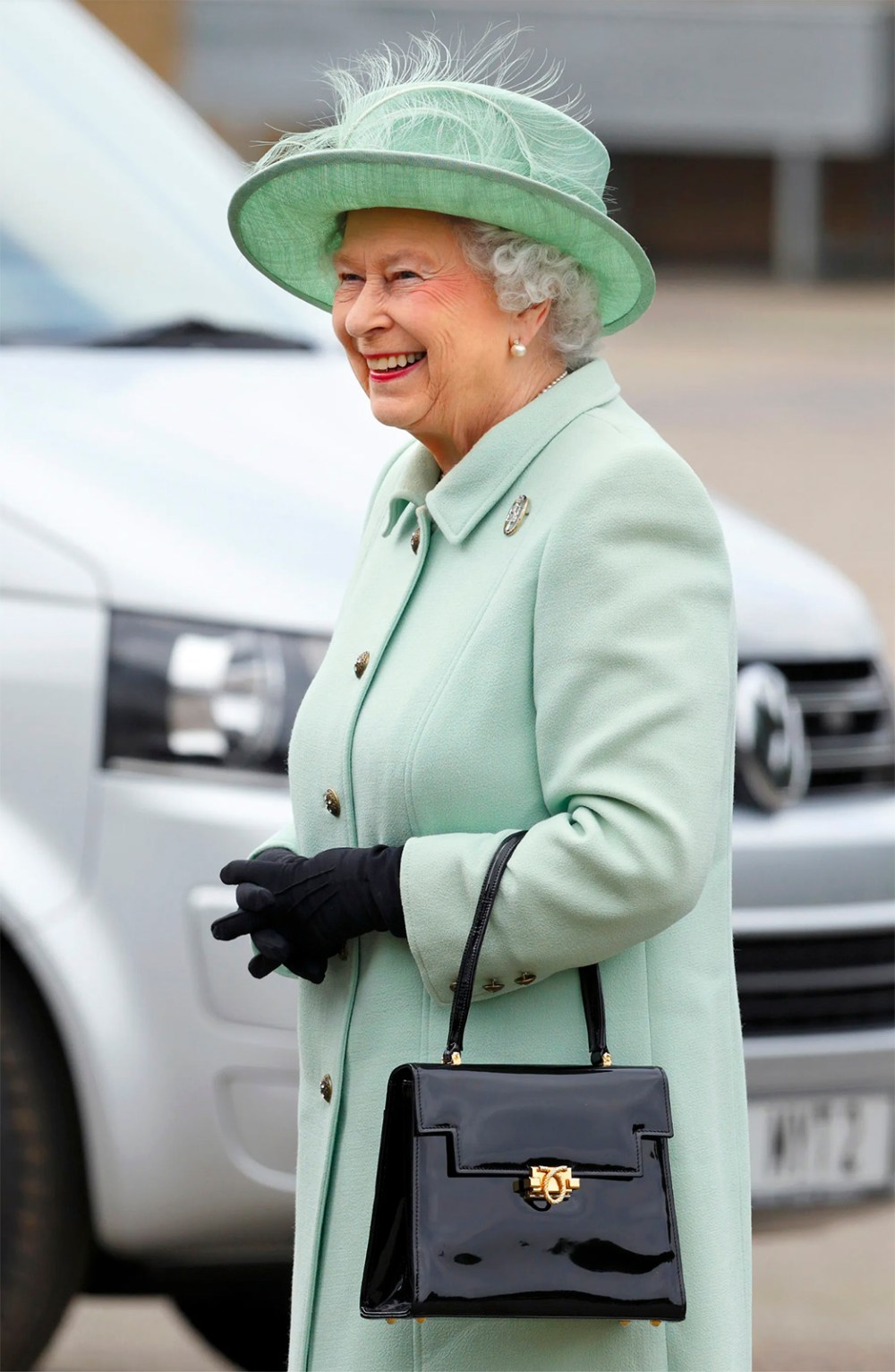Isabel II luciendo su icónico bolso de la marca Launer.